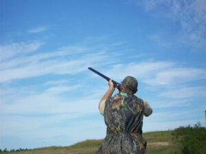 A person shooting a gun in the open sky