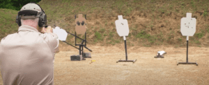 a man shooting a gun at the gun range